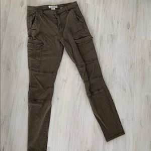 Olive green pants with a lot of pockets.